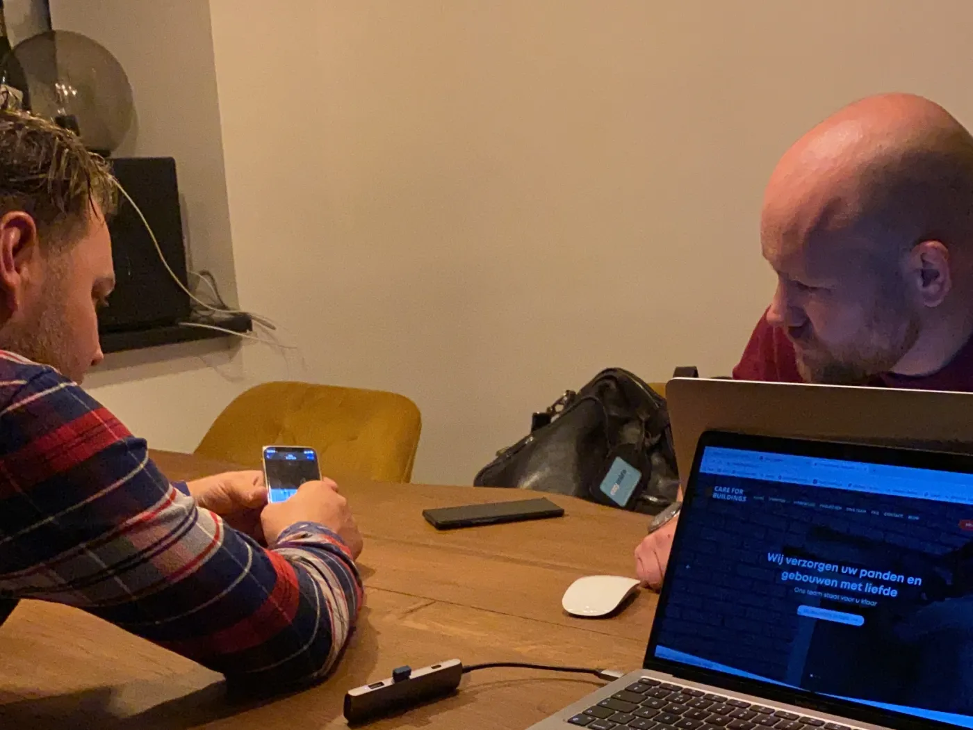Twee collega's overleggen aan tafel met een laptop